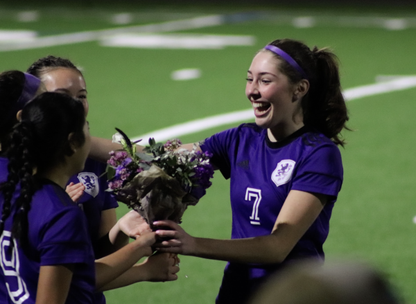 Lily Caldwell (12) receives flowers for Senior Night